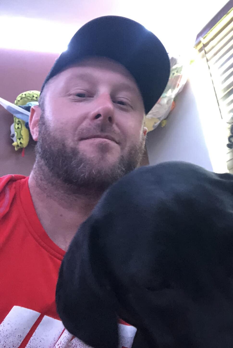 Nicholas Sammartino standing with his dog in a quiet Savannah, Georgia neighborhood.